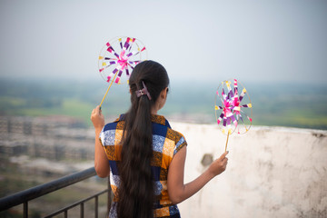 Backside portrait of an young and attractive Indian Bengali brunette girl in western dress standing...