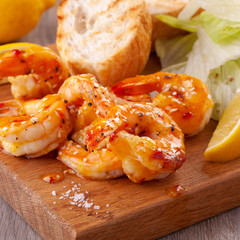 grilled tiger shrimps with spices, sweet and sour sauce, lemon and lettuce