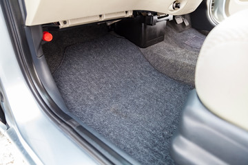 Clean car floor mats of black carpet under front passenger seat in the workshop for the detailing...