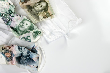 Coronavirus Wuhan illness concept. Chinese money and medical mask