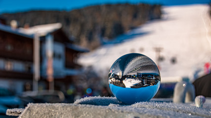 Crystal ball alpine winter landscape shot with snow crystals at Flachau, Salzburg, Austria