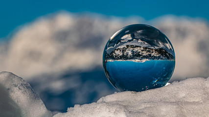 Crystal ball alpine winter landscape shot with snow crystals at Flachau, Salzburg, Austria