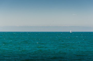 Fototapeta premium Yacht in black sea with sky and horizon