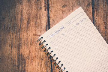 Things to do today - a blank page in a notebook on wooden table. Vintage look