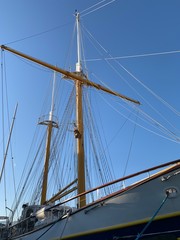 Wooden ship masts in the blue sky background