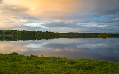 Naklejka na ściany i meble Orange sunset sky and reflection over an irish lake II