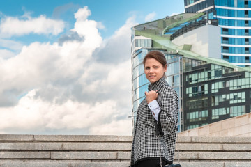 Woman on cityscape background looking straight into the camera. Successful woman concept.