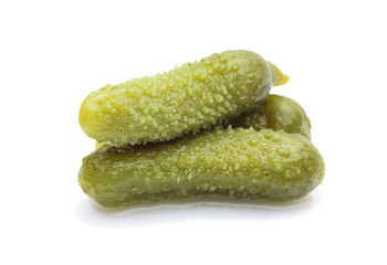 three marinated pickled cucumbers isolated on white