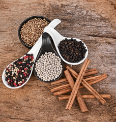 Piper nigrum on a white spoon, placed on a wooden floor