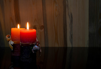 Christmas concept banner with two red candles lighting on wooden background