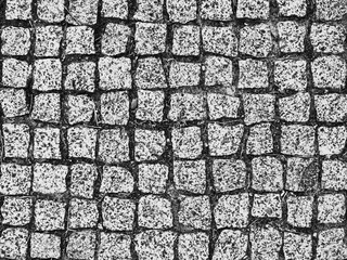 Old paving stones closeup. Black and white background.