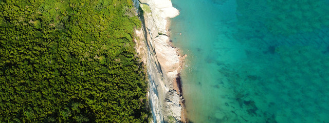 Aerial drone ultra wide photo of iconic white rock steep cliff volcanic bay of Cape Drastis and Peroulades area with tropical deep turquoise clear sea, Corfu island, Ionian, Greece