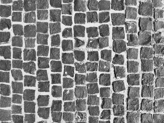 Old paving stones closeup. Black and white background.