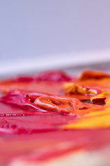 Rote und Gelbe Ölfarbe gemischt auf einer Palette
