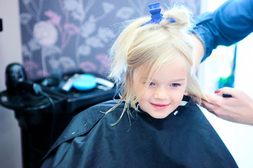 Cute little girl in hairdressing salon. Selective focus