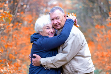 Senior man and woman hugging in an autumn park