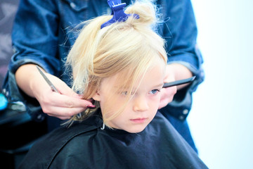 Cute little girl in hairdressing salon. Selective focus
