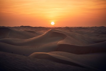 Sand dunes in desert landscape at sunset