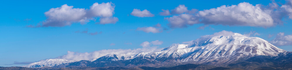 Fototapeta na wymiar Snowy mountain wide panoramic view with cloudy sky. Davraz Mountain in Isparta / Turkey.