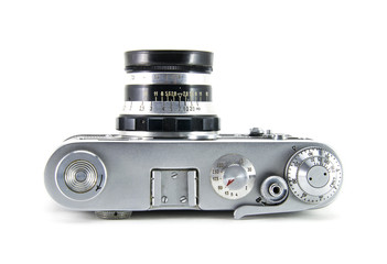 Old film retro camera "fed" with the lens. Metallic black. White isolated background. View from above