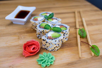 Fototapeta na wymiar Japanese sushi food on a wooden Board. salmon, rice, wasabi, ginger, chopsticks Hashi Japanese cuisine