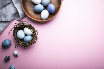 Naturally colorful dyed Easter eggs on pink background