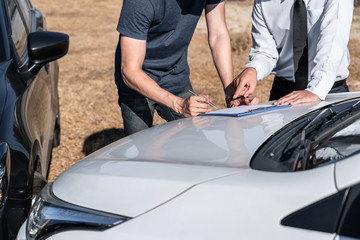 Insurance Agent and customer assessed negotiation, checking and signing on report claim form process after accident collision, Traffic Accident and insurance concept