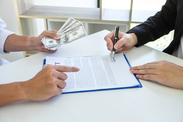 Illegal, dishonest, bribery and corruption concept, Businessman giving bribe money in the envelope of their partner to give success the deal contract in a corruption scam for bribing