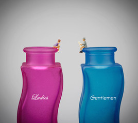 miniature man and woman on pink and blue bottle toilet 