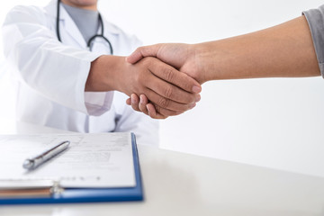 Finishing of consulting, Doctor and patient shaking hands after a good and successful treatment in the hospital, healthcare and assistance concept