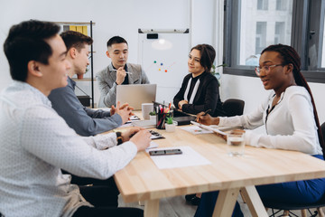 Group of multicultural businesspeople listening their boss speech - asian man manager talking to his team