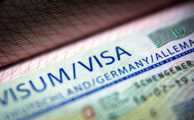 Visa stamp in passport close-up. German visitor visa at border control. Document for multiple...