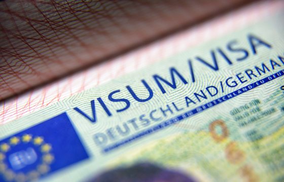 Visa stamp in passport close-up. German visitor visa at border control. Macro view of Schengen visa for tourism and travel in EU.