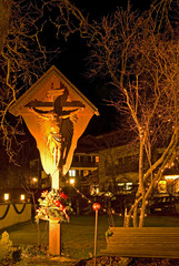 Illuminated wooden cross with trees in background