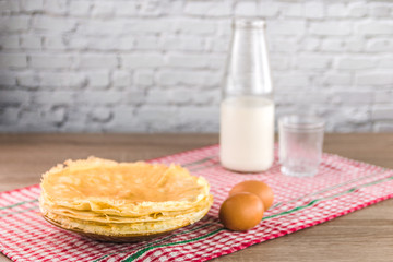 healthy traditional pancakes from rice flour and a jar of milk on wooden table