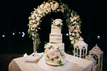 Wedding cake decorated with flowers at the wedding ceremony. Sweet food