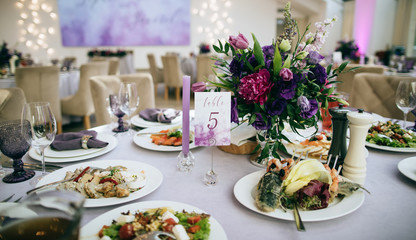  Ideas for wedding. Festive table setting with food on plate and purple flowers
