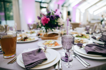 Festive table setting with food on plate and purple flowers