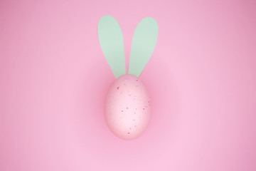 Happy Easter background, with a pink egg with rabbit ears.