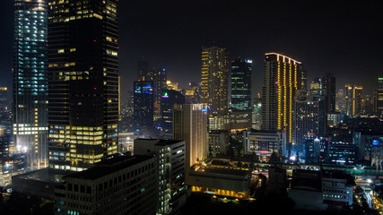Fototapeta na wymiar Modern buildings of Jakarta with lights at night on background, view from Kuningan Jakarta, Indonesia