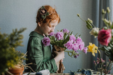 Red-haired cute girl with a bouquet of tulips