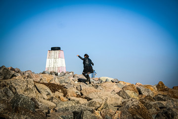 Girl runs on top of a rocky coast