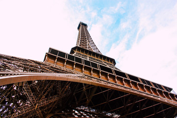 Magestuosa Torre Eiffel vista desde abajo y encuadrada con el cielo de Paris, donde su metal se ve sobrio y brillante