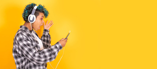 young brunette girl with mobile phone and headphones isolated on background