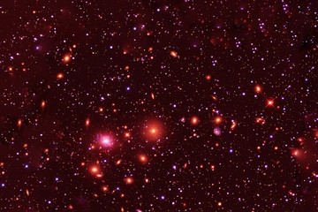 A cluster of stars and galaxies. In red. Elements of this image were furnished by NASA.