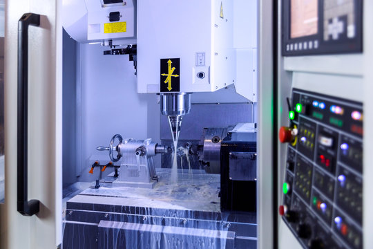 A modern 4-axis cnc vertical milling machine working with water cooling, selective focus on background