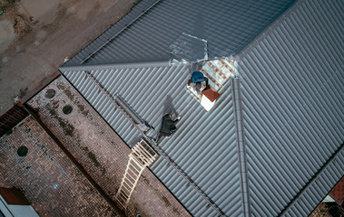 men repair the roof of the cottage