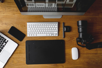 Photographer drawing and retouching image on laptop computer, using a digital tablet and stylus...