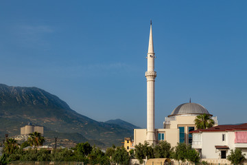 Small mosque in the mountains with one minaret.