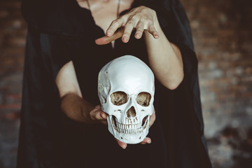 a witch holds a human skull